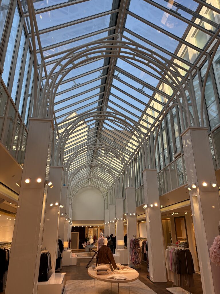 Innenansicht der ersten Etage im Modehaus Lodenfrey in München mit imposantem Glasdach, eleganten Verkaufsflächen und hochwertiger Damen-, und Herrenmode. Das traditionsreiche Kaufhaus zählt zu den bekanntesten Premium-Modehäusern Münchens.
